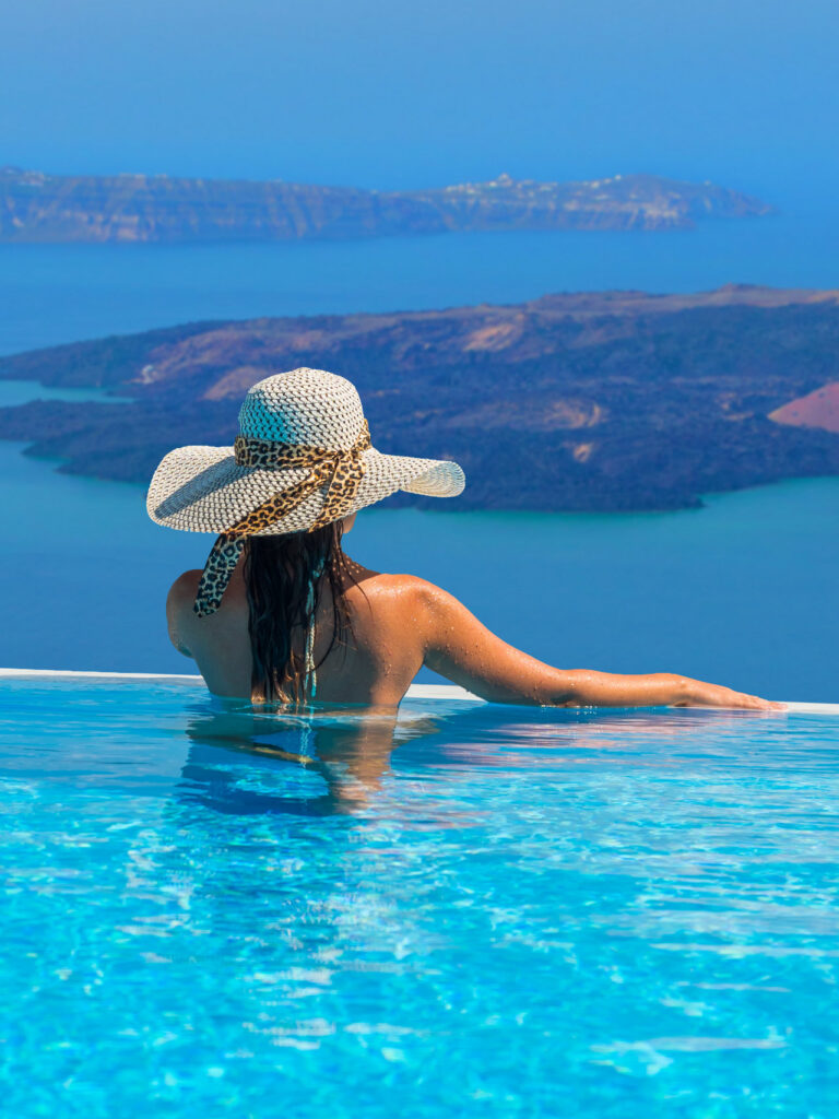 vacation in greece, woman in pool enjoying the view to the aegean sea