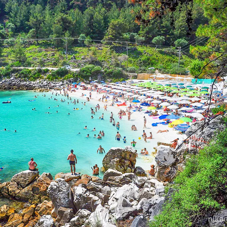 Aerial view of Saliara Marble Beach on Thassos island featuring brilliant white marble pebbles and vibrant turquoise Aegean waters
